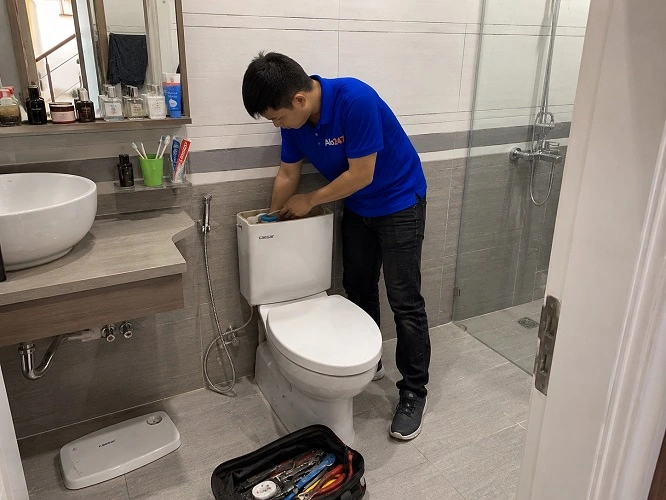 Thợ alo247 đang sửa bồn cầu lỗi không xả được