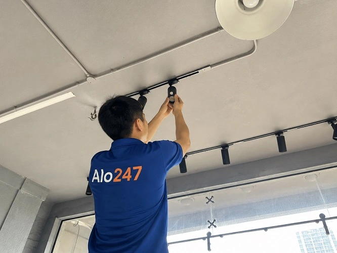 Thợ alo247 đang thay bóng đèn tại Hà Nội