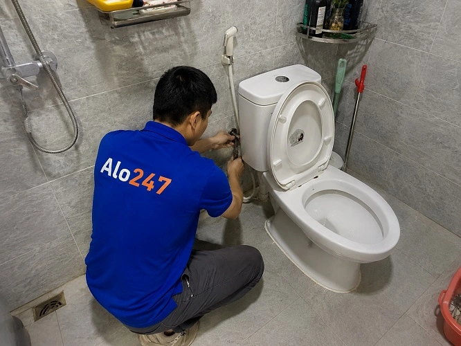 Thợ alo247 đang thay vòi xịt nhà vệ sinh
