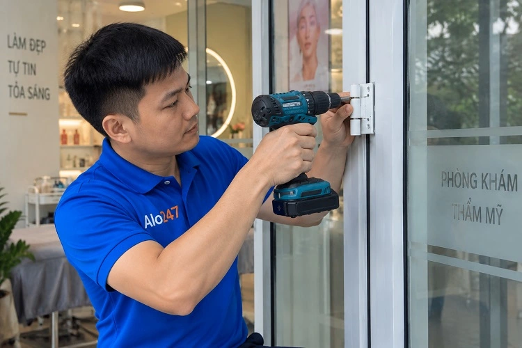 Thợ alo247 đang thay bản lề cửa nhựa lõi thép