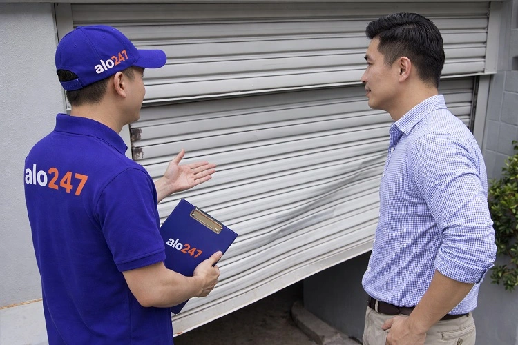 Thợ kiểm tra trước khi sửa nan cửa cuốn bị cong, gãy