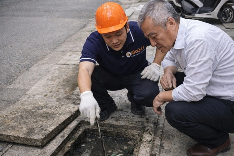 thợ alo247 đang khảo sát cống bị tắc nghẹt cùng khách hàng