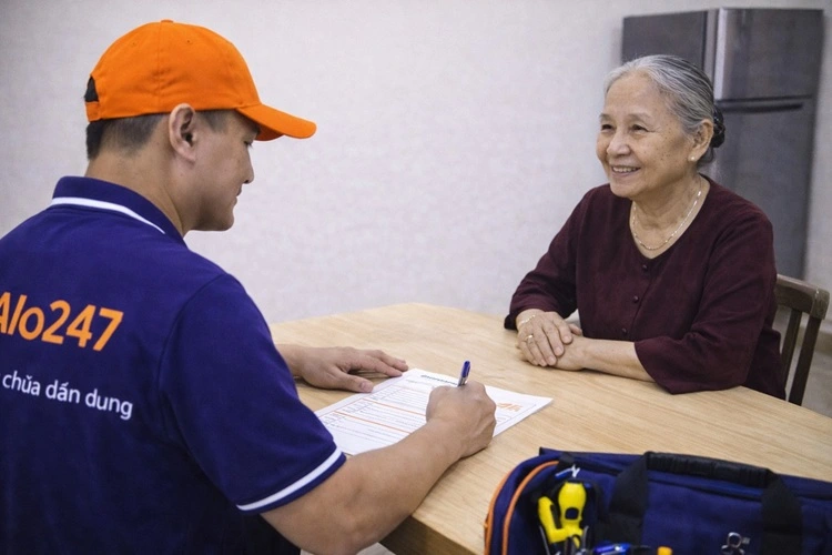 thợ alo247 viết phiếu bảo hành dịch vụ sửa tủ lạnh cho khách hàng