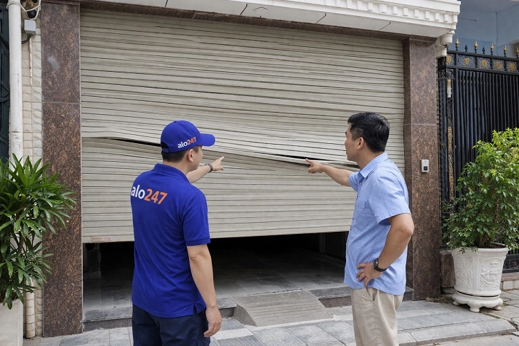 Thợ kiểm tra tình trạng cửa cuốn bị lệch nan