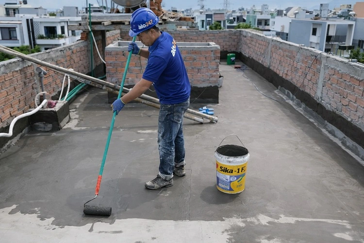 Nhân viên Alo247 đang lăn lớp sơn chống thấm chuyên dụng cho mái nhà