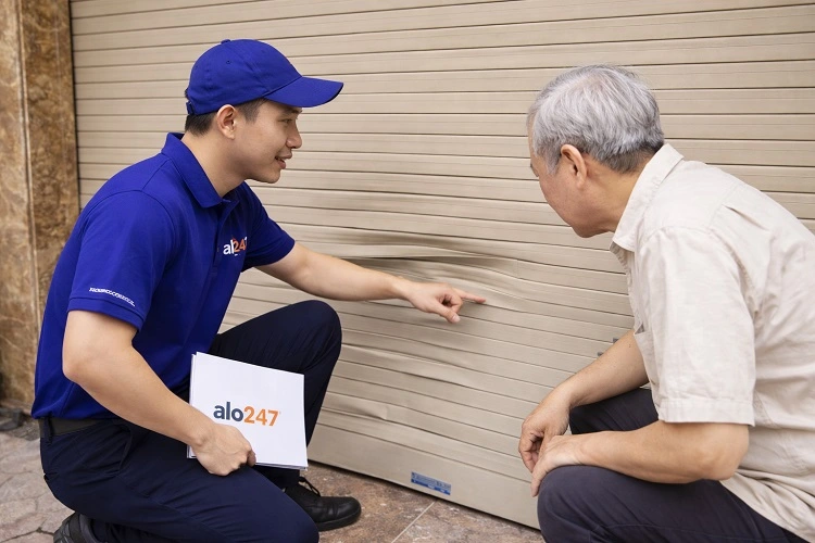 Kỹ thuật viên kiểm tra cửa cuốn hư hỏng