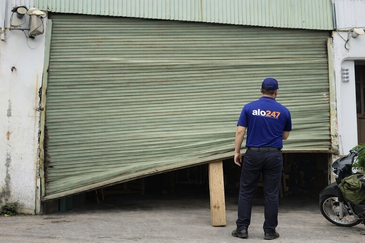 Kỹ thuật viên kiểm tra cửa cuốn hư hỏng