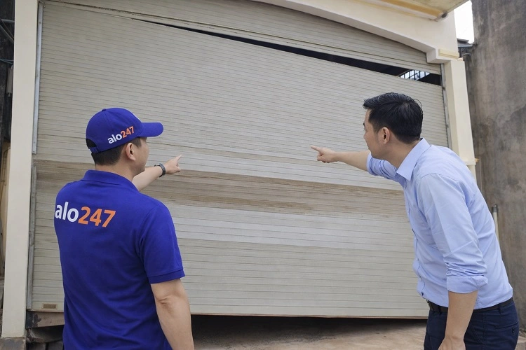 Kỹ thuật viên kiểm tra cửa cuốn hư hỏng