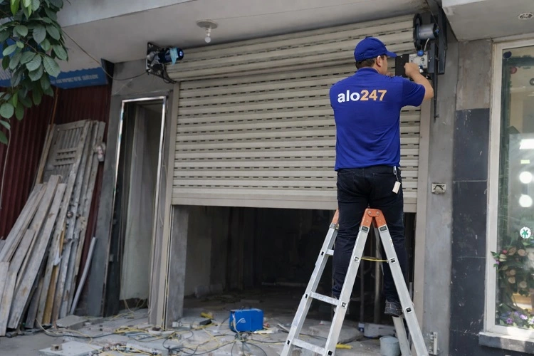 Kỹ thuật viên kiểm tra và chỉnh cửa cuốn