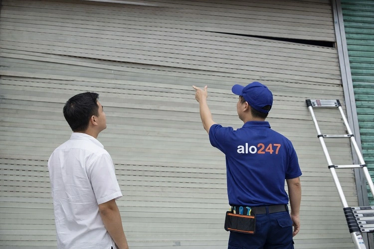 Thợ kiểm tra cửa cuốn bị móp méo, xổ lô