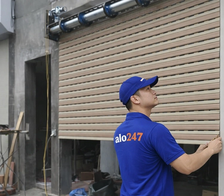 Thợ kiểm tra tình trạng cửa cuốn bị kẹt