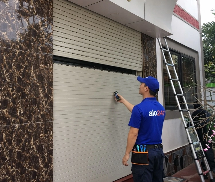 Thợ kiểm tra tình trạng cửa cuốn hỏng