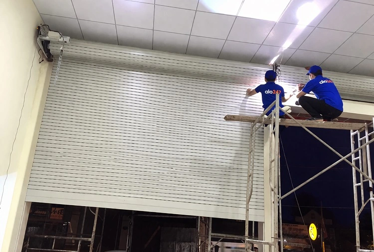 Thợ kiểm tra và thay hộp điều khiển cửa cuốn