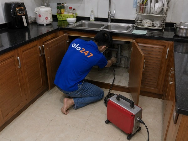 Thợ Alo247 dùng máy lò xo thông tắc cống chậu rửa bát tại Phú Diễn