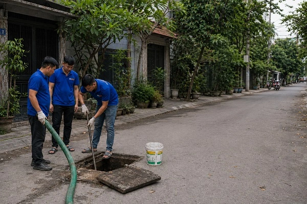 Thợ alo247 đang đưa ống xuống bể phốt để hút chất thải tại Phú Diễn