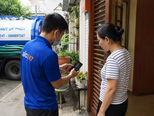 Thợ giải thích phương án hút bể phốt bằng xe chân không cho khách hàng tại Phúc Lộc