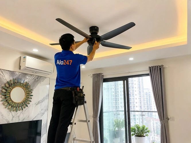 Thợ Alo247 đang kiểm tra quạt trần chạy yếu