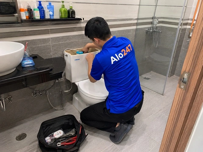 Thợ alo247 đang sửa bồn cầu bị hỏng phao cấp nước