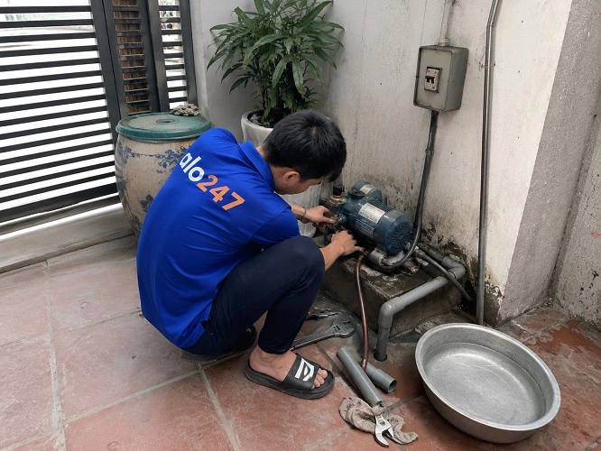 Thợ alo247 đang sửa máy bơm bị hỏng