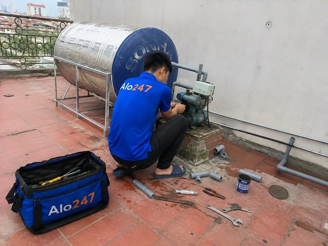 Thợ alo247 đang sửa máy bơm không chạy