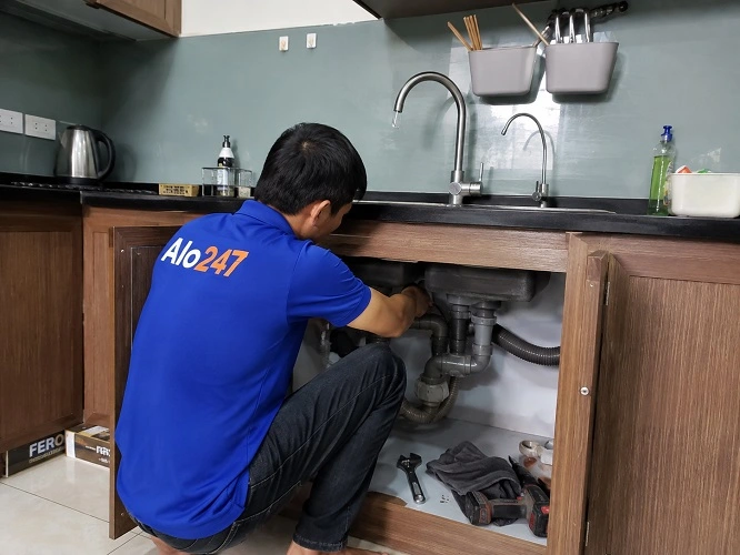 Thợ alo247 đang sửa ống bồn rửa bát bị rò rỉ