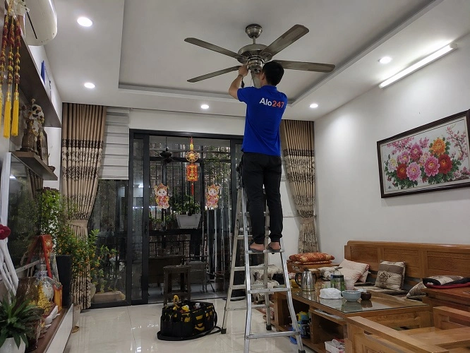 Thợ alo247 đang sửa quạt trần bị lỗi kêu to