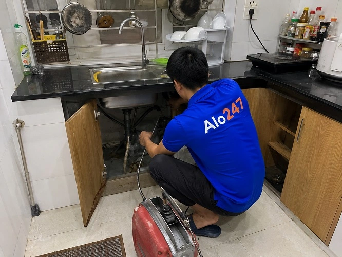 Thợ alo247 đang thông tắc cống bồn rửa bát