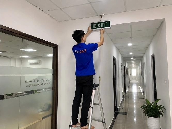 thợ alo247 đang lắp đèn exit chỉ hướng