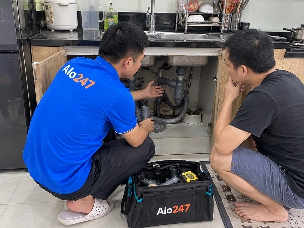 Thợ Alo247 đang tư vấn phương án khắc phục bồn rửa bát bị thoát nước kém cho khách hàng