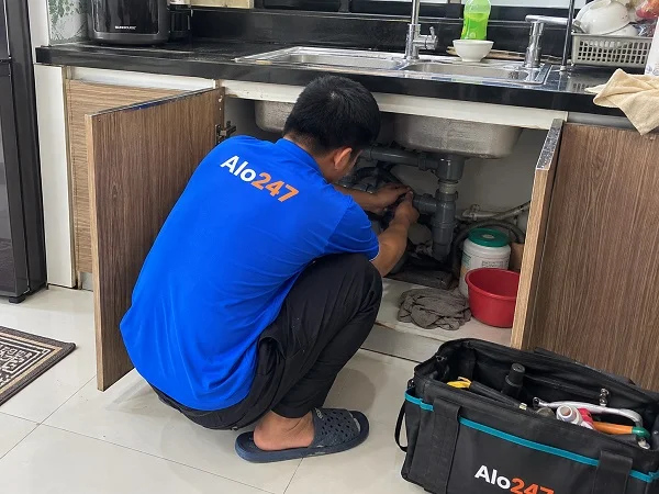 Thợ Alo247 đang khắc phục tình trạng nước rò rỉ dưới bồn rửa bát