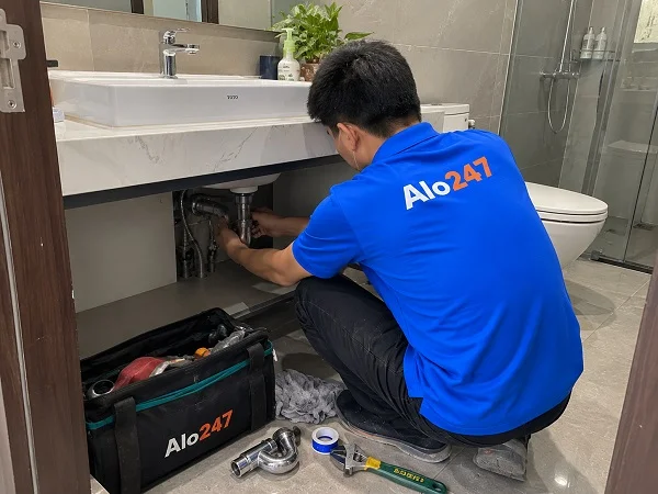 Thợ Alo247 đang xử lý tình trạng nước chảy ngược tại bồn rửa